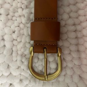 Brown belt, with gold accents. Never worn. Too big for me